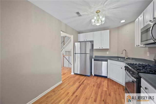 21 Capica Ct Unit 89, South Amboy, NJ 08879 - kitchen with appliances with stainless steel finishes, dark countertops, white cabinetry, a chandelier, and recessed lighting
