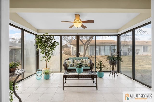 sunroom with plenty of natural light, tile patterned floors, and ceiling fan