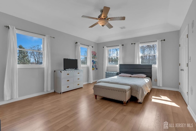 bedroom with visible vents, light wood-style flooring, a ceiling fan, and baseboards