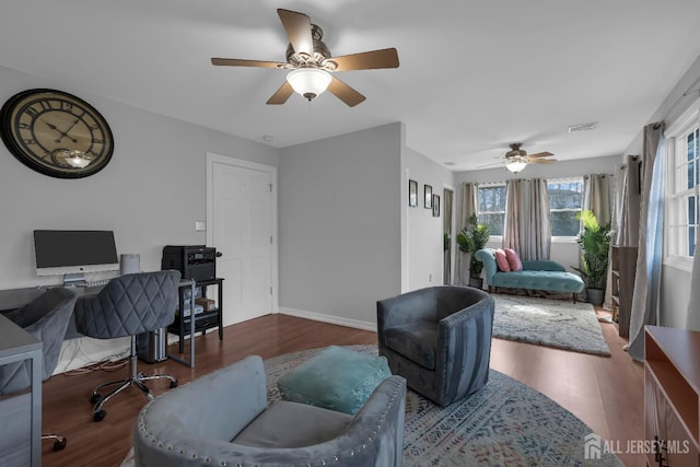 home office featuring visible vents, baseboards, wood finished floors, and a ceiling fan