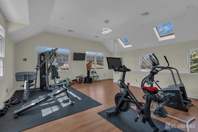 workout area with visible vents, wood finished floors, baseboards, and vaulted ceiling