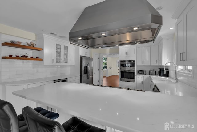 kitchen with white cabinetry, light countertops, exhaust hood, and stainless steel appliances