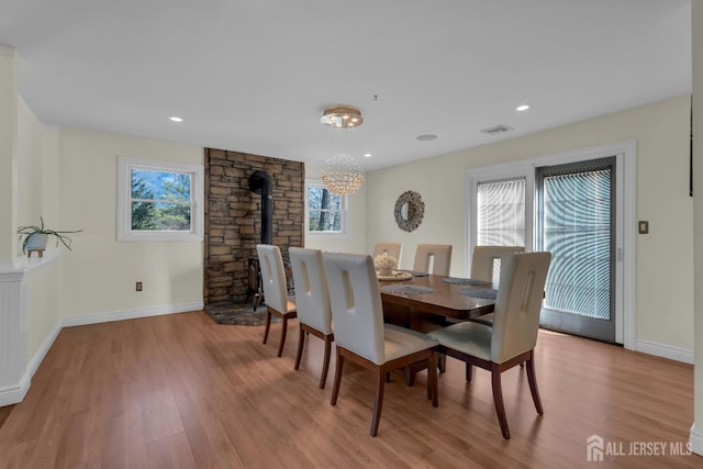 dining room with an inviting chandelier, wood finished floors, visible vents, and baseboards