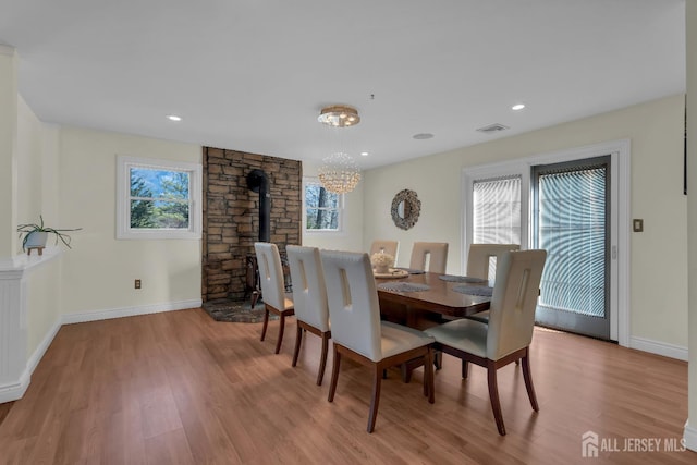 896 Kearney Dr, North Brunswick, NJ 08902 - dining space featuring wood finished floors, a wood stove, visible vents, an inviting chandelier, and baseboards