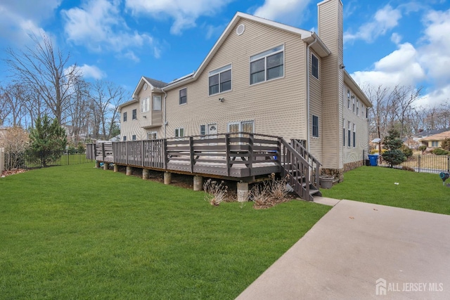 896 Kearney Dr, North Brunswick, NJ 08902 - back of property with a chimney, a lawn, fence, a patio area, and a wooden deck