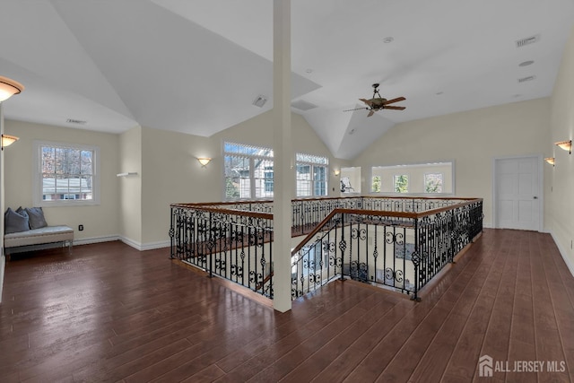 hallway featuring an upstairs landing, visible vents, baseboards, and wood finished floors