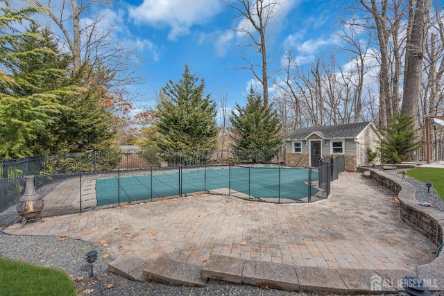 view of swimming pool with an outbuilding, a patio, fence, an exterior structure, and a fenced in pool