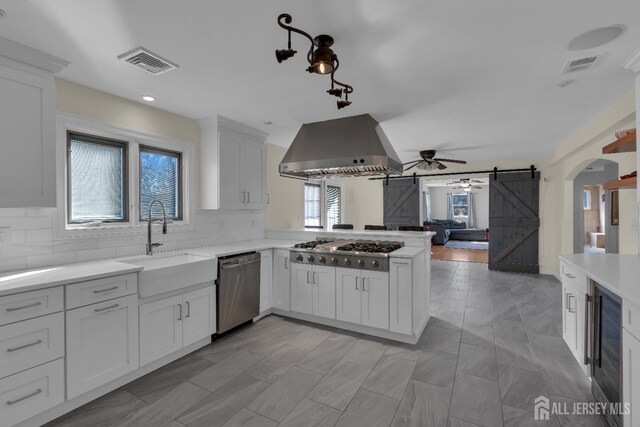 896 Kearney Dr, North Brunswick, NJ 08902 - kitchen featuring wall chimney exhaust hood, stainless steel appliances, visible vents, and a sink