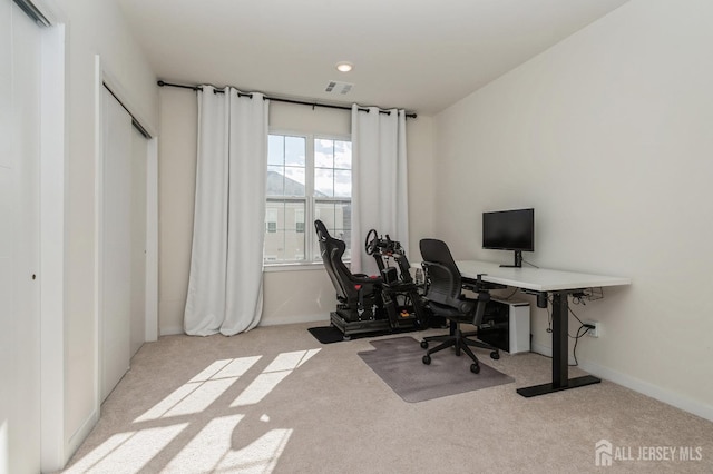 office space featuring light carpet, visible vents, and baseboards