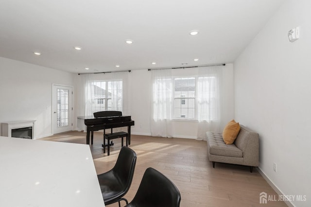 sitting room with light wood-type flooring, baseboards, and recessed lighting