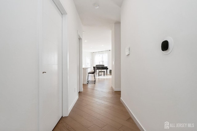 hallway with baseboards and wood finished floors