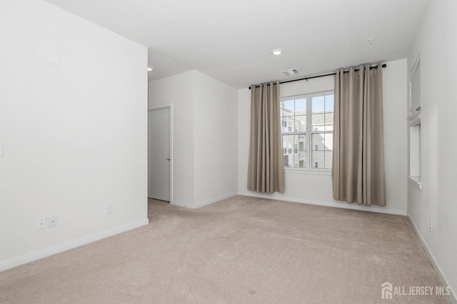 empty room featuring light carpet, recessed lighting, visible vents, and baseboards