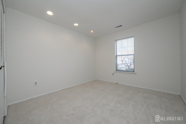 unfurnished room featuring recessed lighting, light colored carpet, visible vents, and baseboards