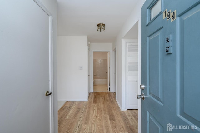 entryway featuring baseboards and light wood-type flooring