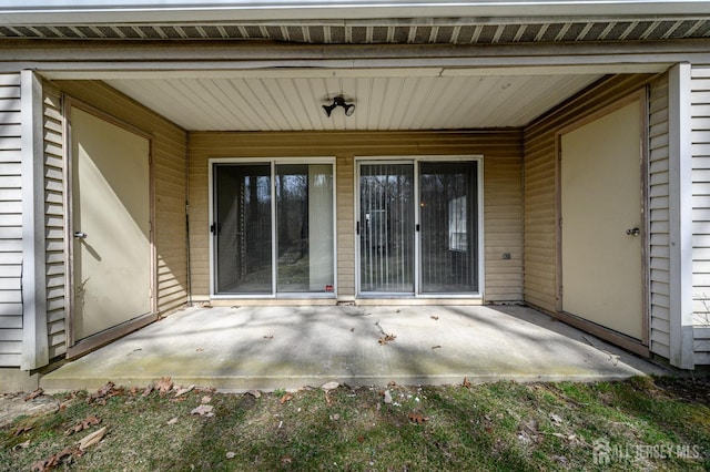 view of exterior entry with a patio