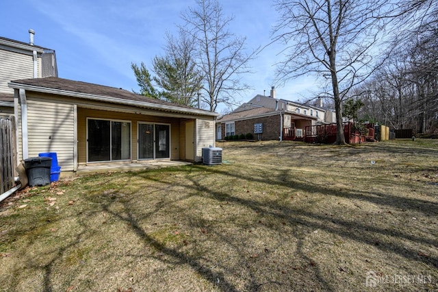 rear view of house featuring a patio area, central air condition unit, and a lawn