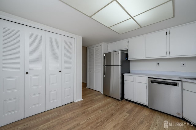 kitchen featuring white cabinets, stainless steel appliances, light countertops, and light wood-style floors