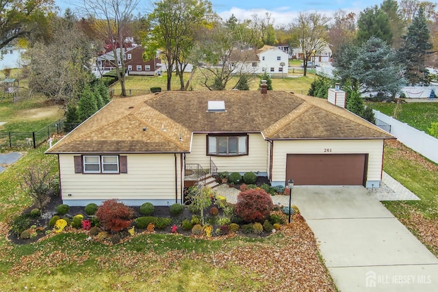 ranch-style home with a garage and a front lawn