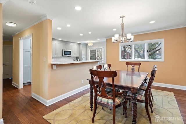 dining room with a chandelier, crown molding, and dark hardwood / wood-style floors