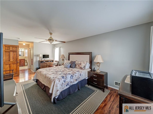 bedroom featuring a ceiling fan, dark wood-style flooring, visible vents, and baseboards