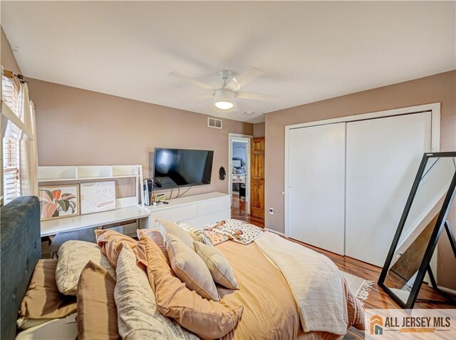 bedroom featuring hardwood / wood-style floors, a closet, and ceiling fan