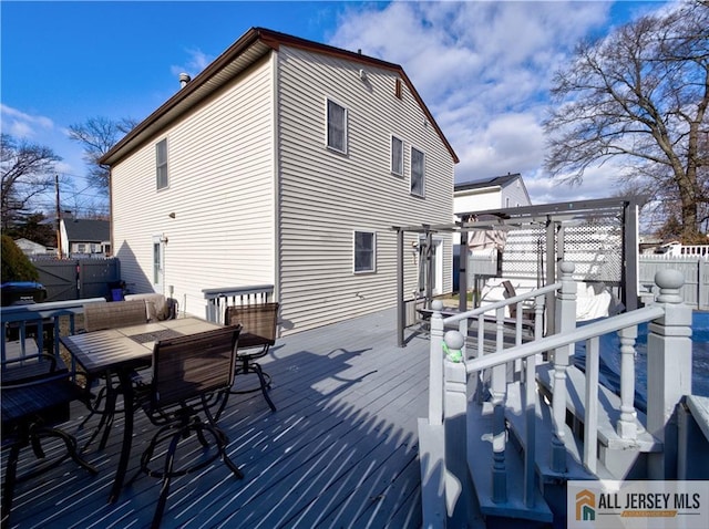 wooden deck with fence, a pergola, and outdoor dining space