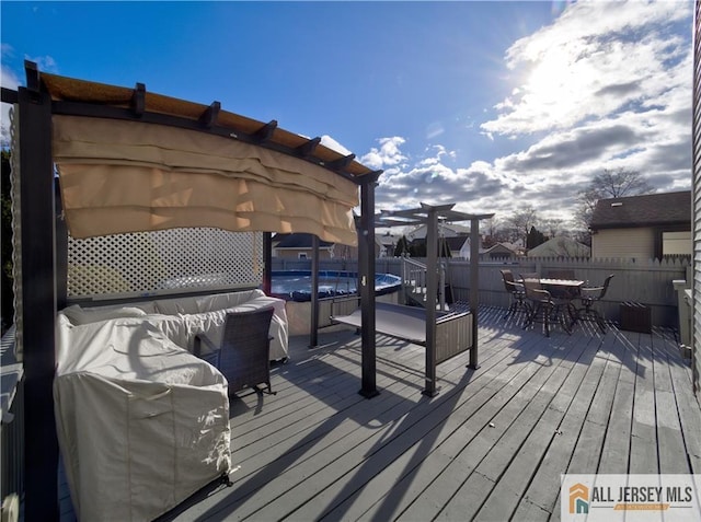 deck featuring fence and a pergola