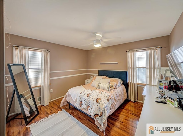 bedroom with ceiling fan, baseboards, and wood finished floors