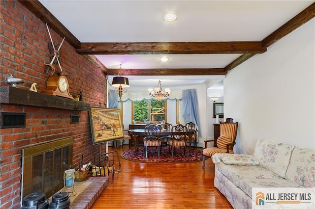 8 Harold Ave, Edison, NJ 08820 - living room with a chandelier, wood finished floors, beamed ceiling, a brick fireplace, and brick wall