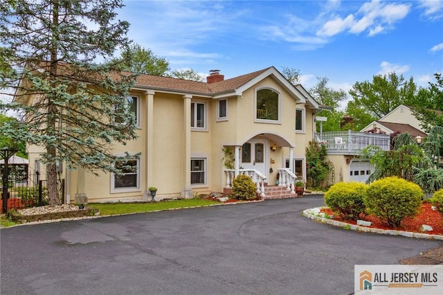 8 Harold Ave, Edison, NJ 08820 - view of front of home with stucco siding, a chimney, asphalt driveway, and a garage