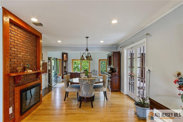 8 Harold Ave, Edison, NJ 08820 - dining area featuring ornamental molding, light wood-style floors, recessed lighting, a brick fireplace, and french doors