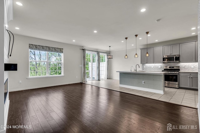 44 Begonia Ln, Monroe, NJ 08831 - kitchen with stainless steel appliances, gray cabinets, open floor plan, decorative backsplash, and light wood finished floors