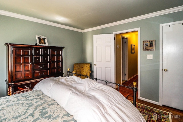 bedroom with crown molding, baseboards, and wood finished floors