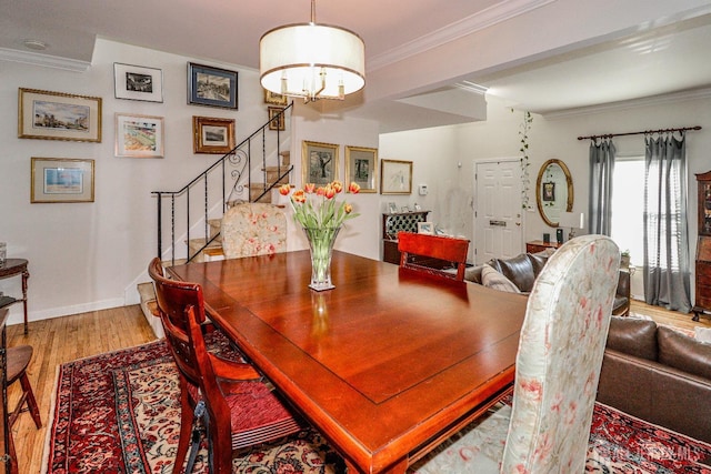 dining area featuring baseboards, stairway, wood finished floors, and crown molding