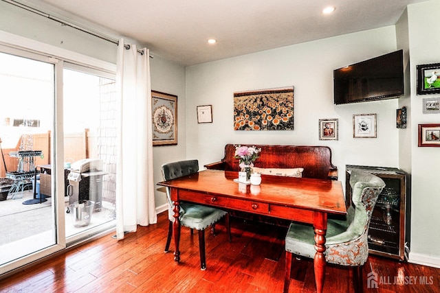 dining room with beverage cooler, baseboards, wood finished floors, and recessed lighting