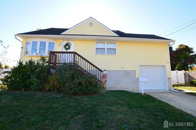 view of front of property featuring a garage and a front lawn