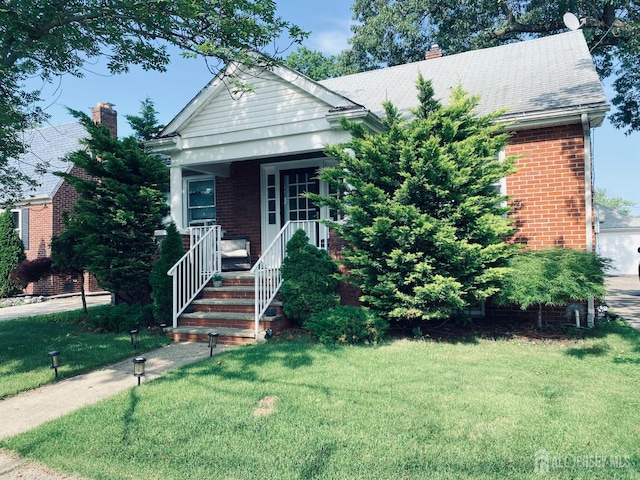 142 Liberty St, Fords, NJ 08863 - view of front of house featuring brick siding, a front lawn, a porch, and a chimney