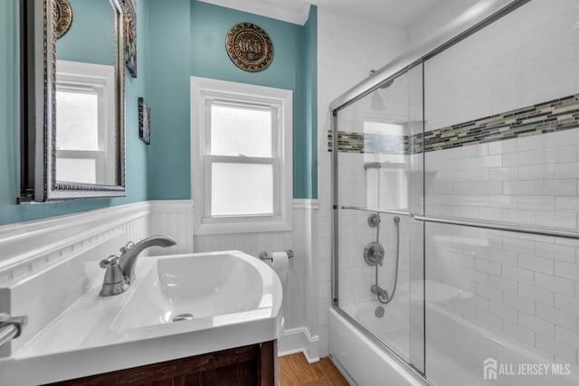 143 Emerson St, Carteret, NJ 07008 - bathroom with vanity, wainscoting, combined bath / shower with glass door, plenty of natural light, and wood finished floors