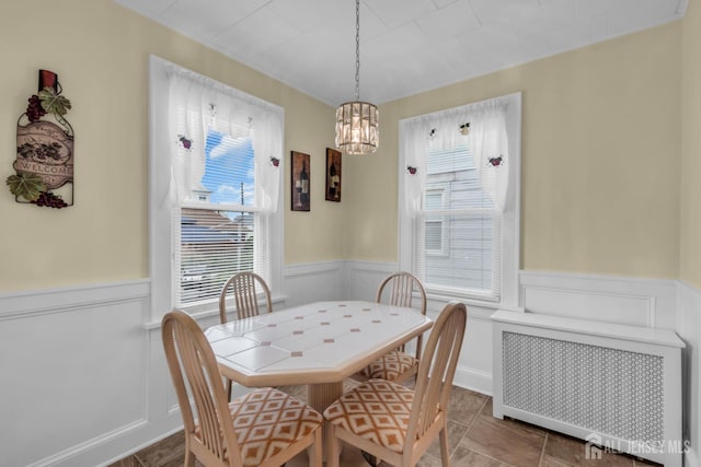 143 Emerson St, Carteret, NJ 07008 - dining room with wainscoting, radiator, plenty of natural light, a decorative wall, and a chandelier