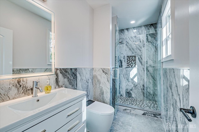 full bathroom with vanity, tile walls, toilet, and a marble finish shower