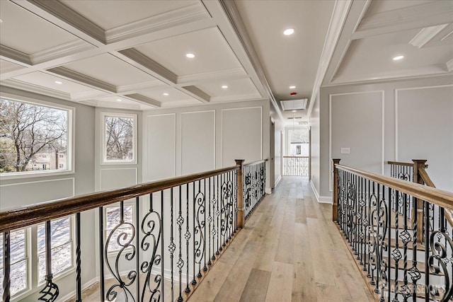 hall featuring beam ceiling, a decorative wall, and coffered ceiling