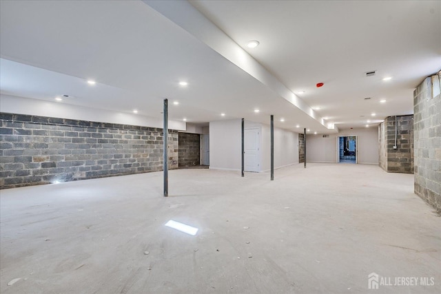 finished below grade area featuring recessed lighting, visible vents, and concrete block wall