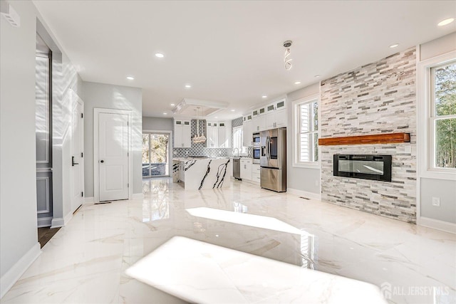 living room featuring recessed lighting, baseboards, marble finish floor, and a fireplace