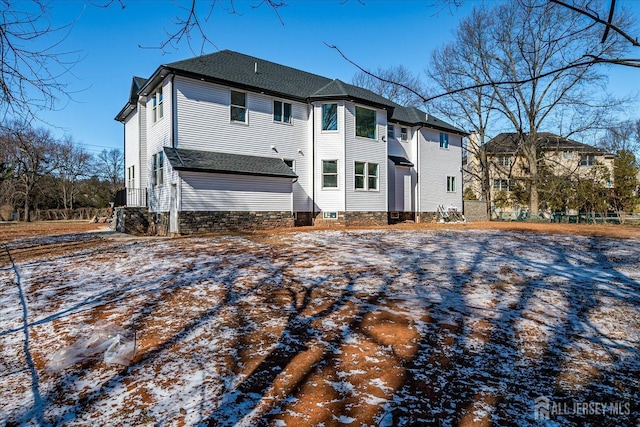 view of snow covered back of property