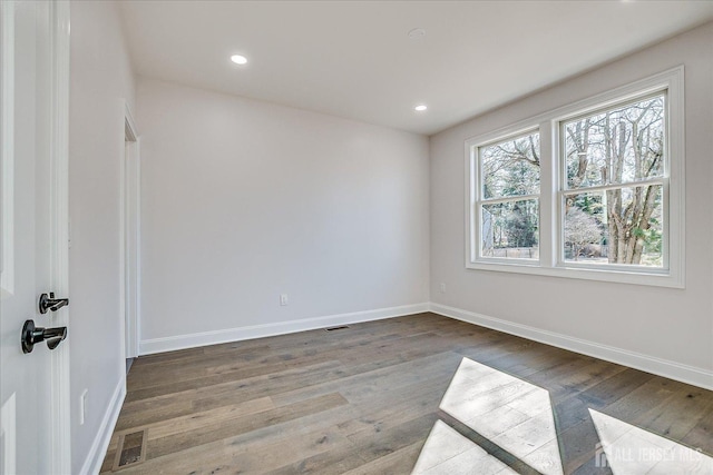 empty room featuring visible vents, recessed lighting, baseboards, and wood finished floors