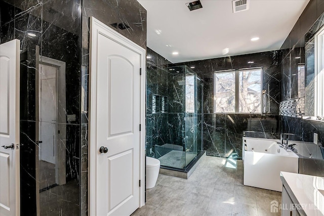 bathroom with vanity, visible vents, a tub, a shower stall, and tile walls