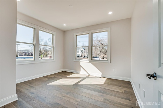 spare room with recessed lighting, baseboards, and wood finished floors