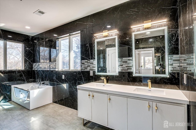 bathroom with plenty of natural light, visible vents, and a sink