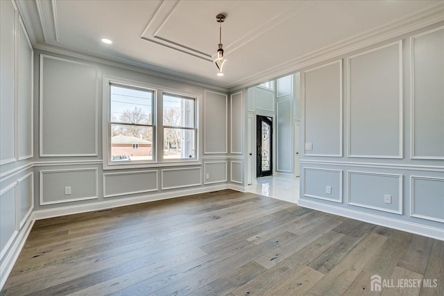 unfurnished room featuring a decorative wall and hardwood / wood-style floors