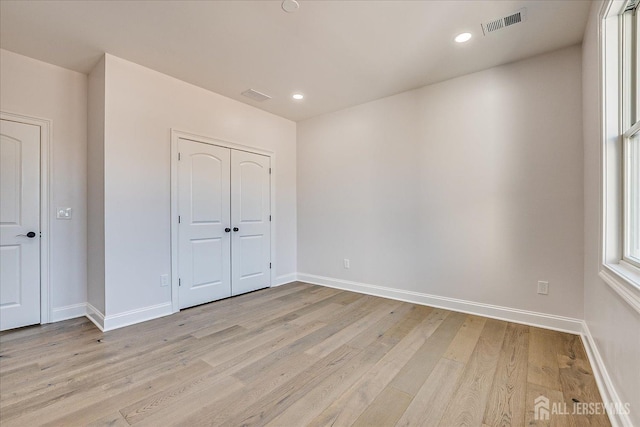 unfurnished bedroom with visible vents, baseboards, and light wood-style flooring